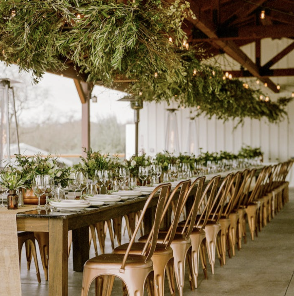 Vineyard Pavilion reception table beneath hanging greenery