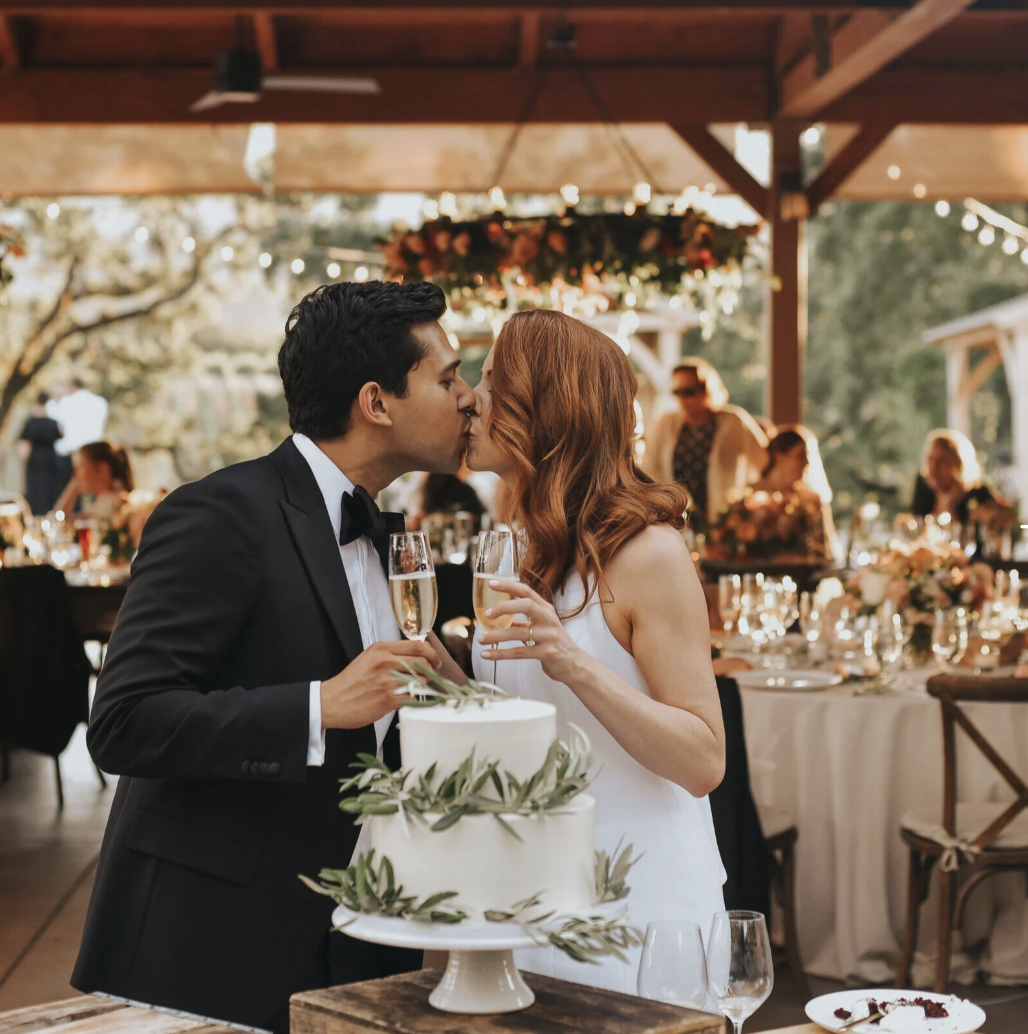 Couple celebrating in the Vineyard Pavilion with wedding cake